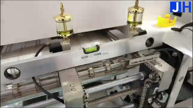 Spirit level on the R10 reflow oven conveyor track at the board entrance, checking that the oven is level before a profiling run